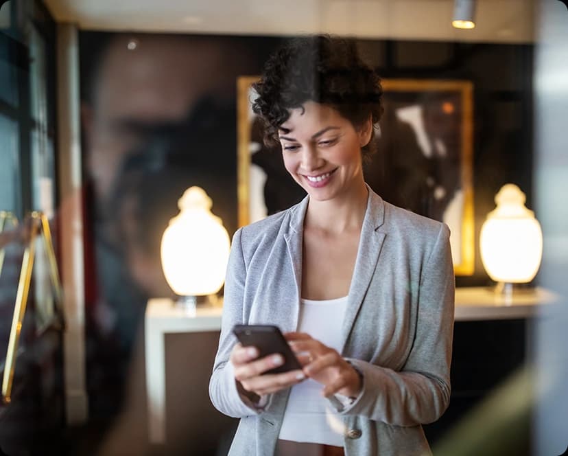 Persona de negocios sonriendo mientras usa su teléfono